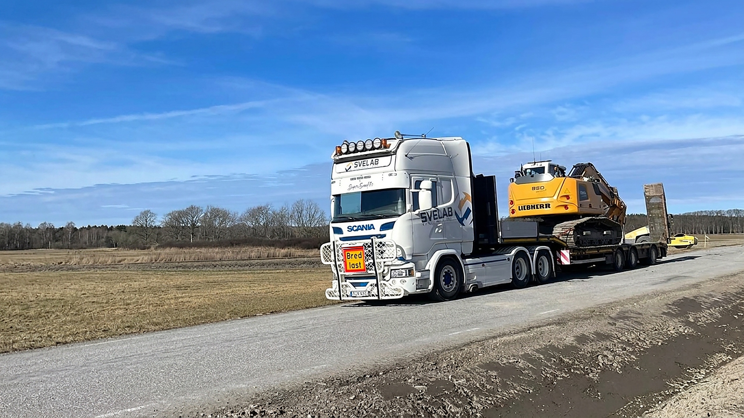 SVELAB Scania lastbil med Liebherr-grävmaskin på landsväg